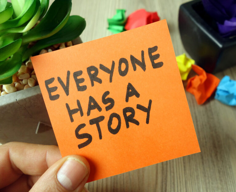 Slogan everyone has a story handwritten on sticky note